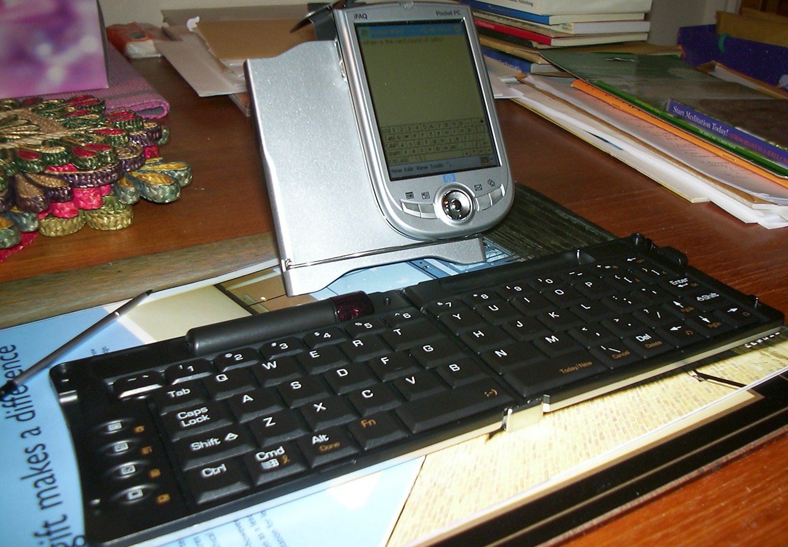 Photograph shows the iPaq PDA on a stand and Belkin stowaway keyboard unfolded on a desk at home