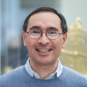 headshot of Paul Trafford in front of a museum display case with part of an astrolabe in the background